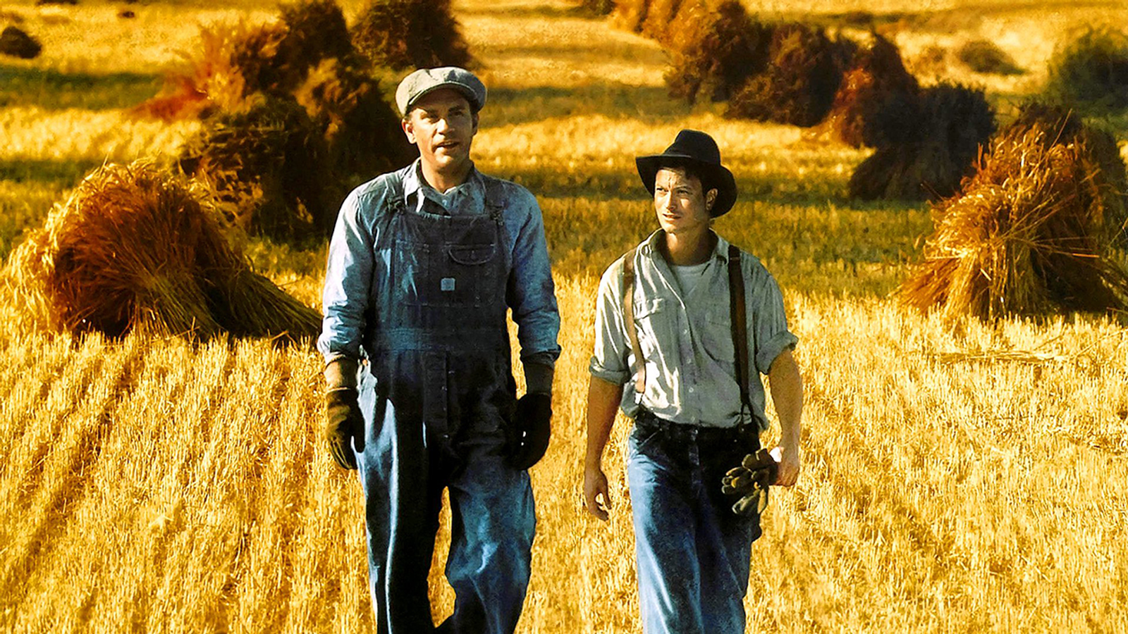 George and Lennie in the 1992 film adaption of Of Mice and Men in a field of wheat basking in the setting sun.