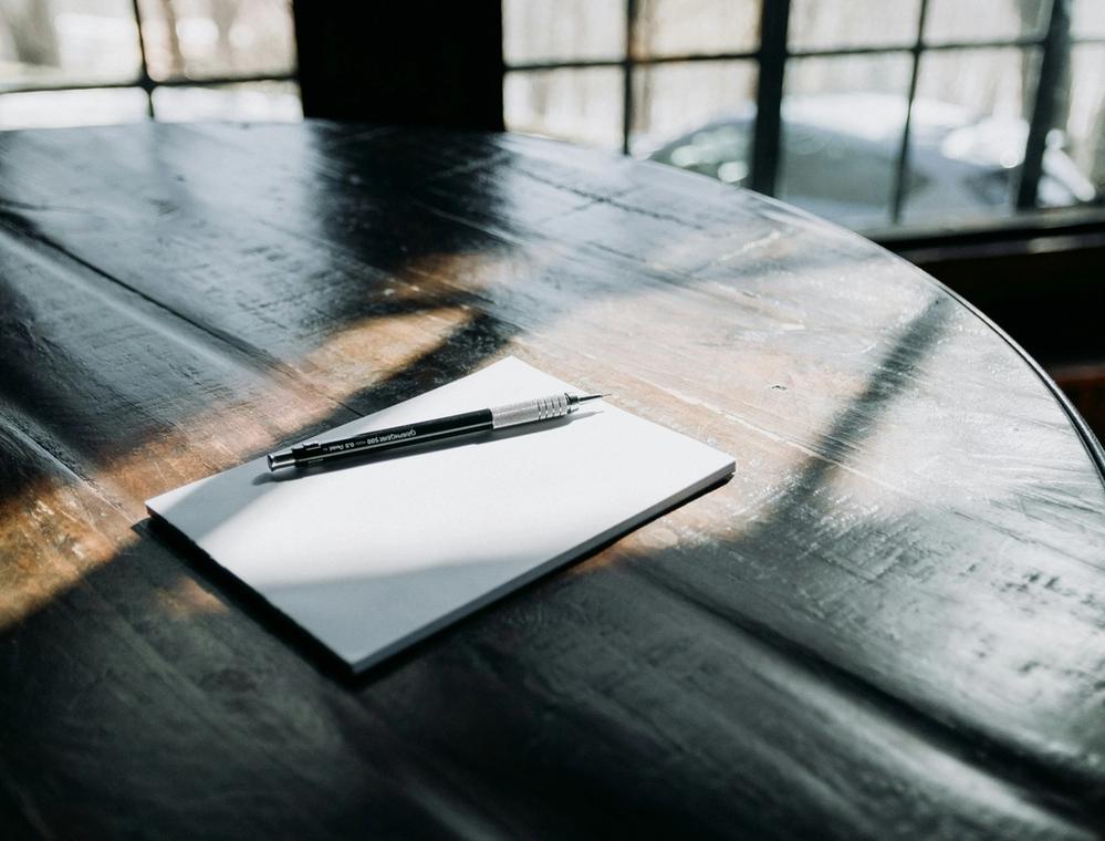 Pen and paper on wooden table