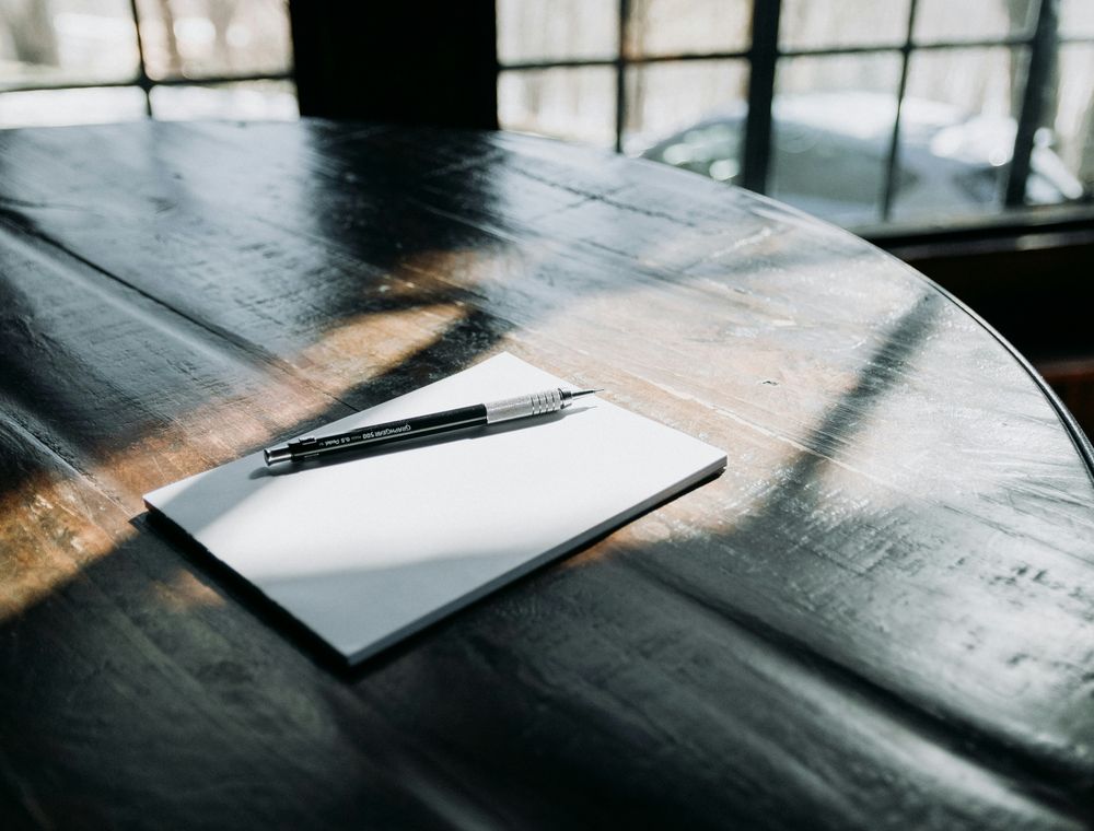 Pen and paper on wooden table