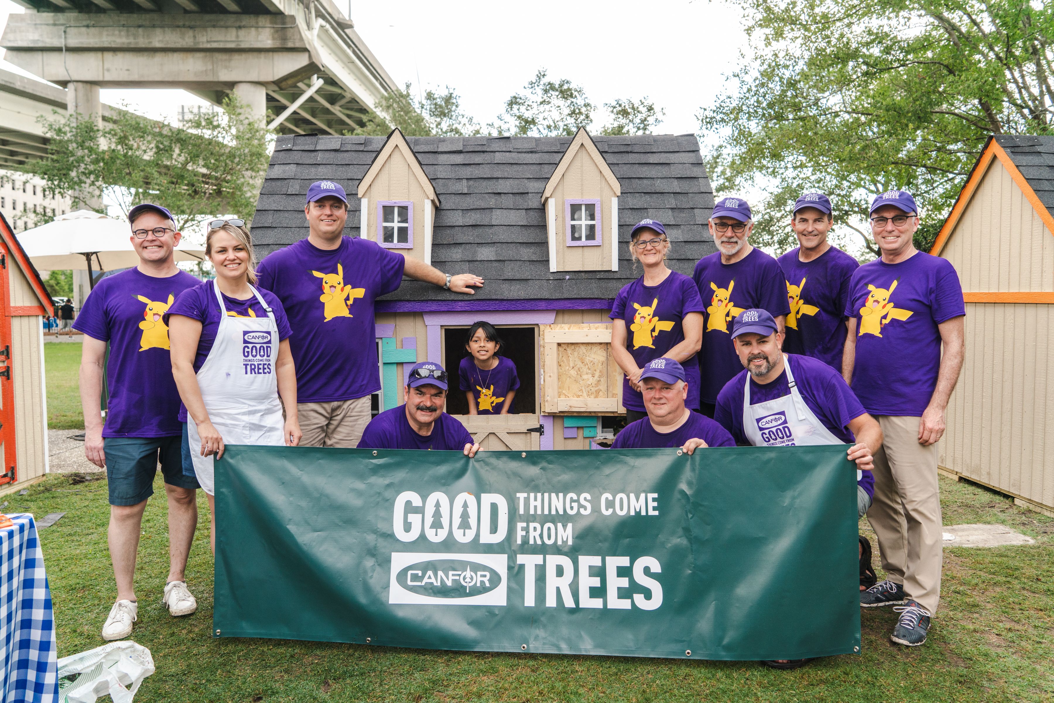 a group of people are posing for a picture in front of a playhouse .