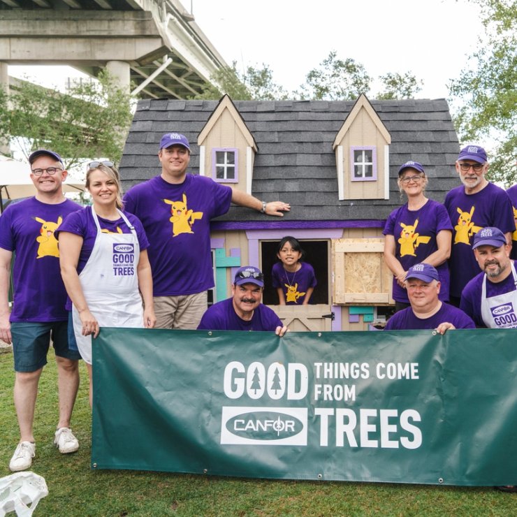 a group of people are posing for a picture in front of a playhouse .