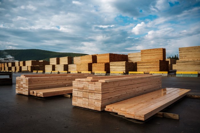 a bunch of wooden boards are stacked on top of each other in a yard.