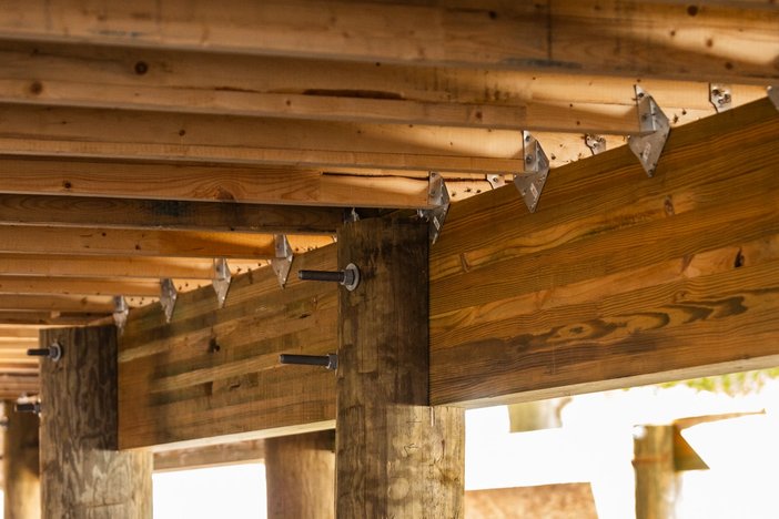the underside of a wooden deck under construction.