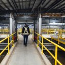 a man is walking on a walkway at Canfor's Prince George Water Treatment facility.