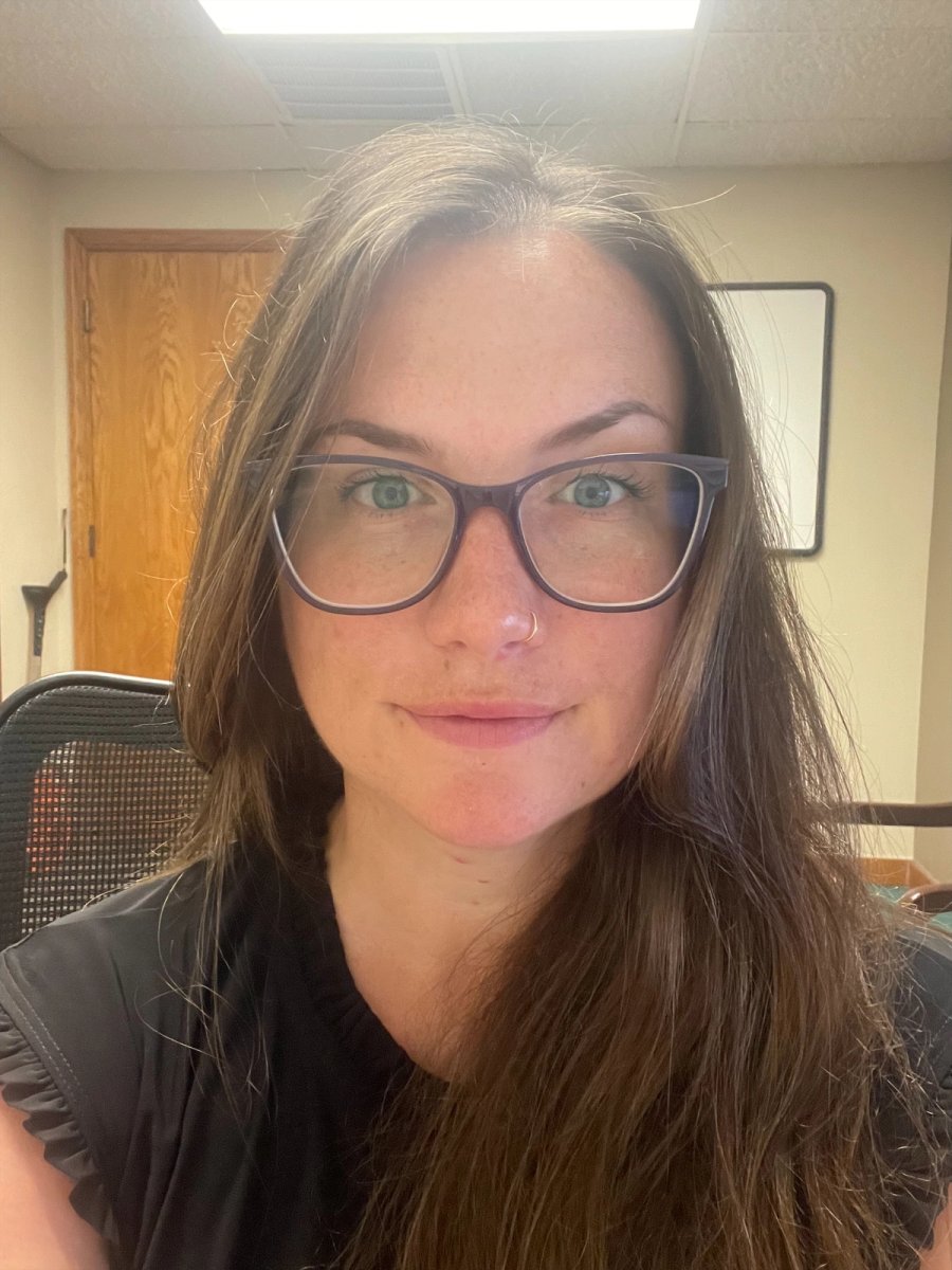 a woman wearing glasses and a black shirt smiles for the camera