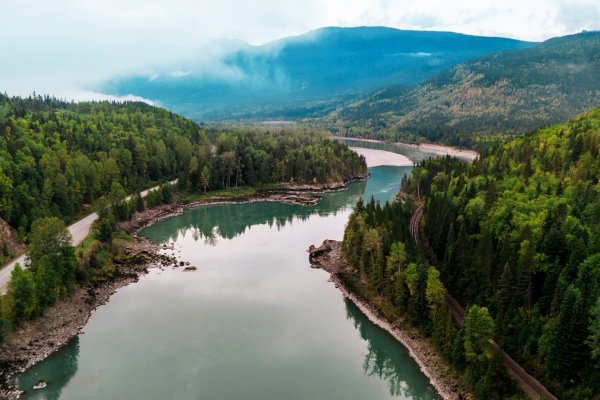an aerial view of a river surrounded by mountains and trees .