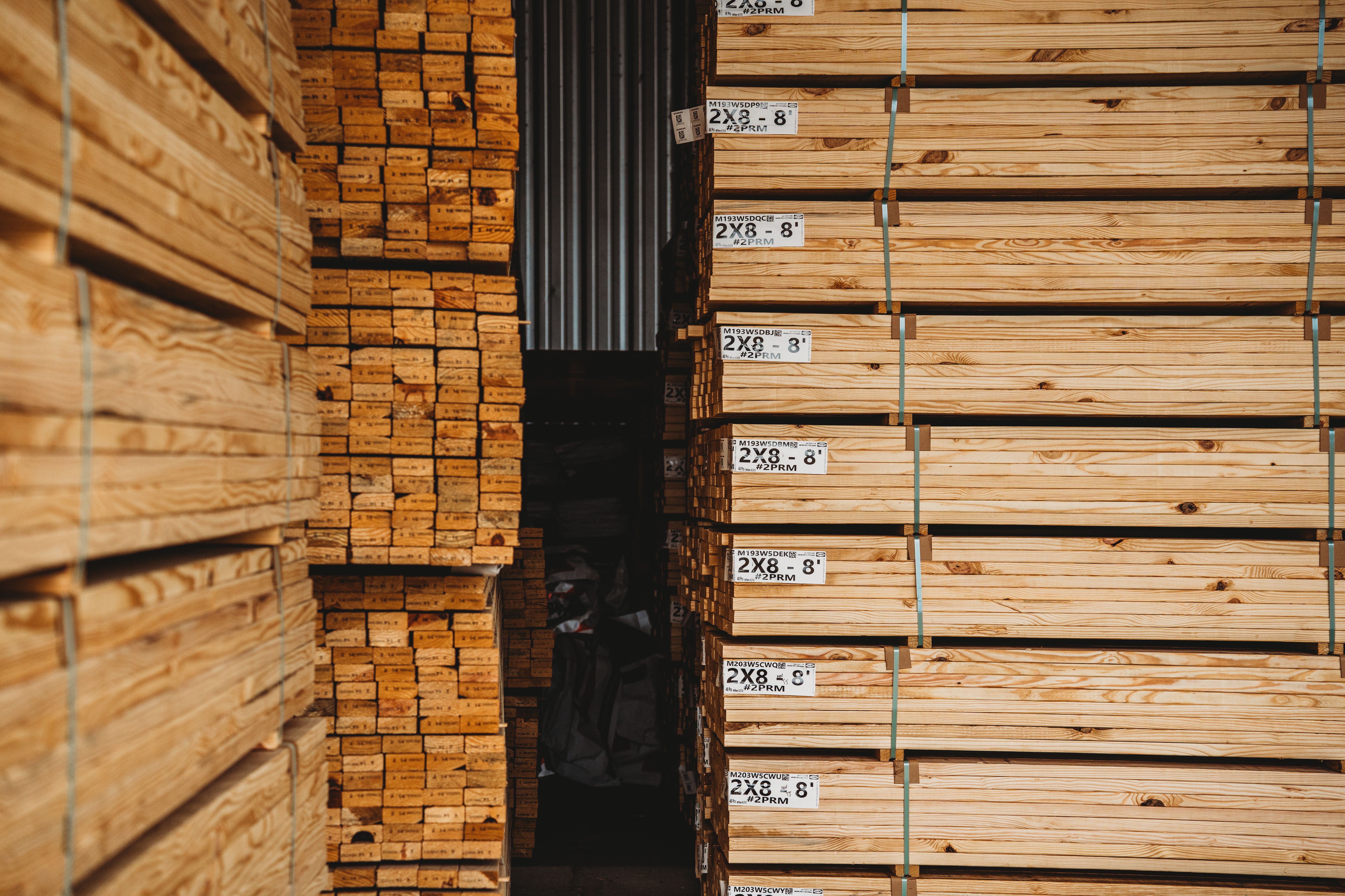 Large stacks of bundled lumber in a warehouse.