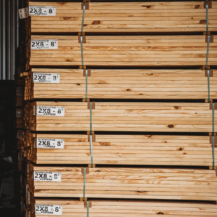Large stacks of bundled lumber in a warehouse.