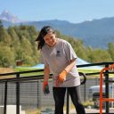two women are smiling and laughing while pushing a utility cart at a volunteer event. .