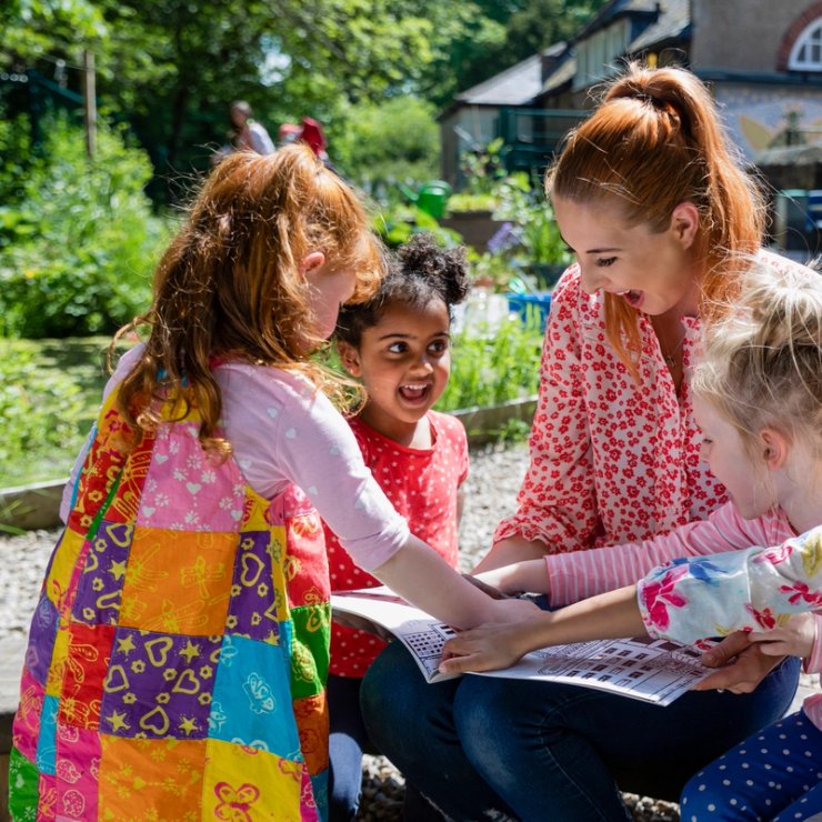a teacher and children are reviewing a book.
