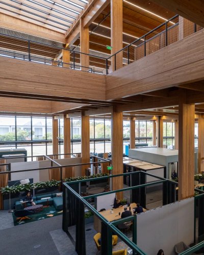 a large wooden building with lots of windows and people working in it .