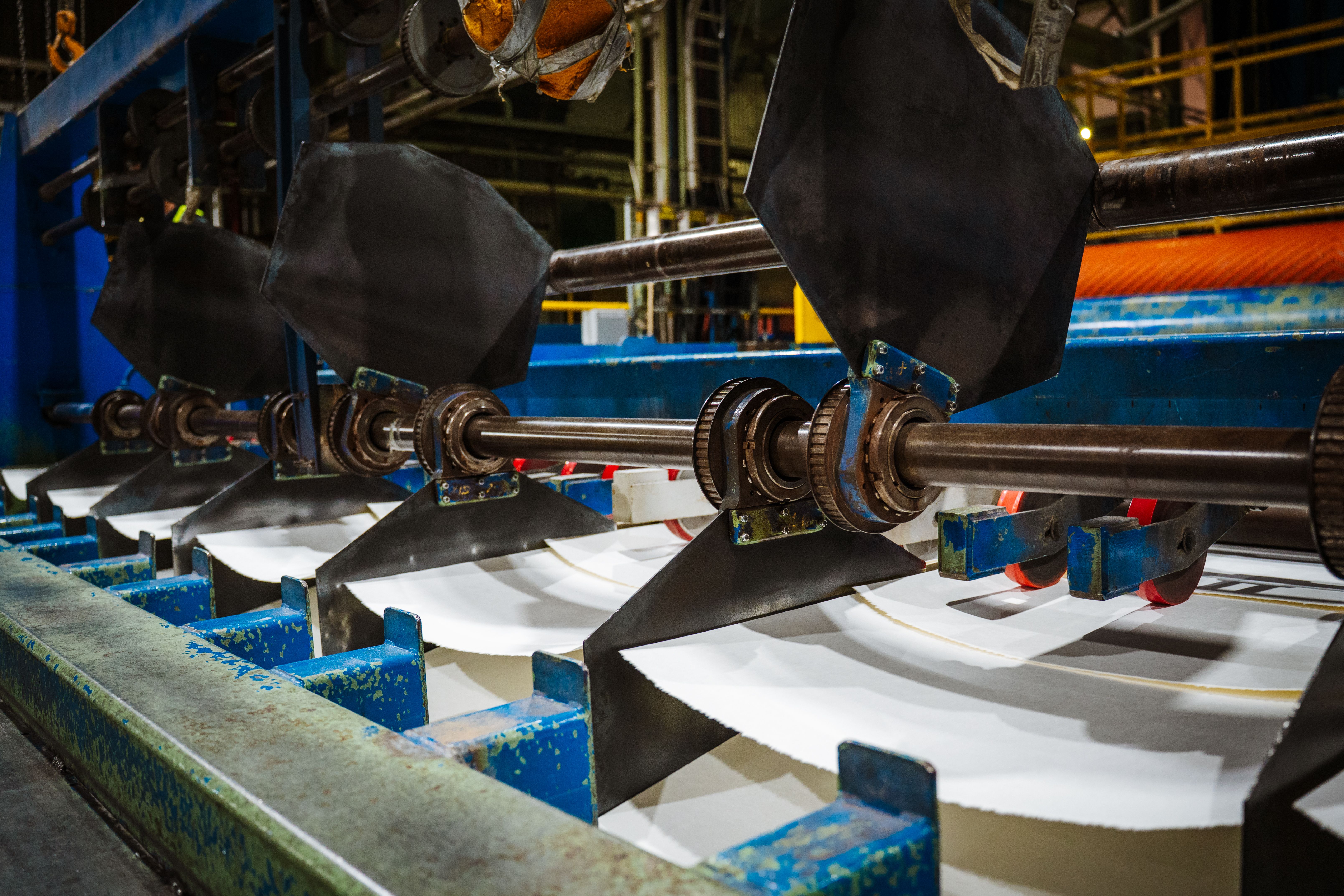 a machine is cutting paper in a factory .
