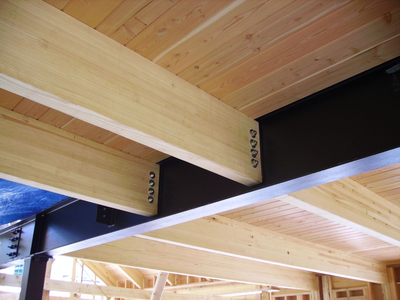 a wooden ceiling with a metal beam attached to it.