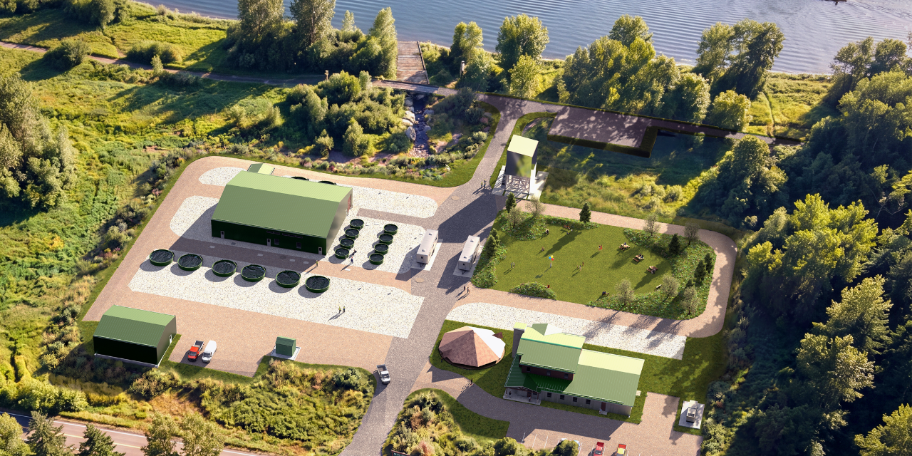 Aerial view of a modern facility with green buildings and circular tanks next to a river, surrounded by trees.
