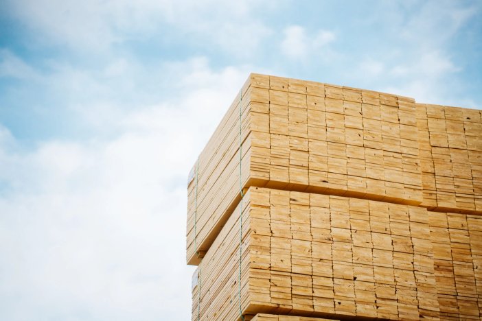 a stack of wooden blocks against a blue sky with clouds .
