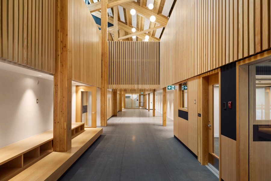 a long hallway with wooden walls and columns in a building .