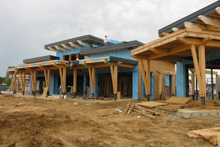 a large house is being built in a dirt field.