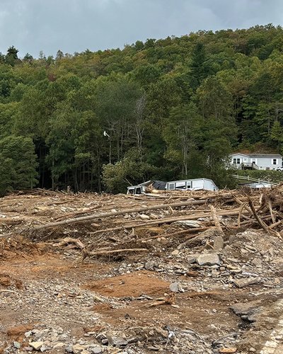 there is a lot of debris in the middle of a field with a house in the background .