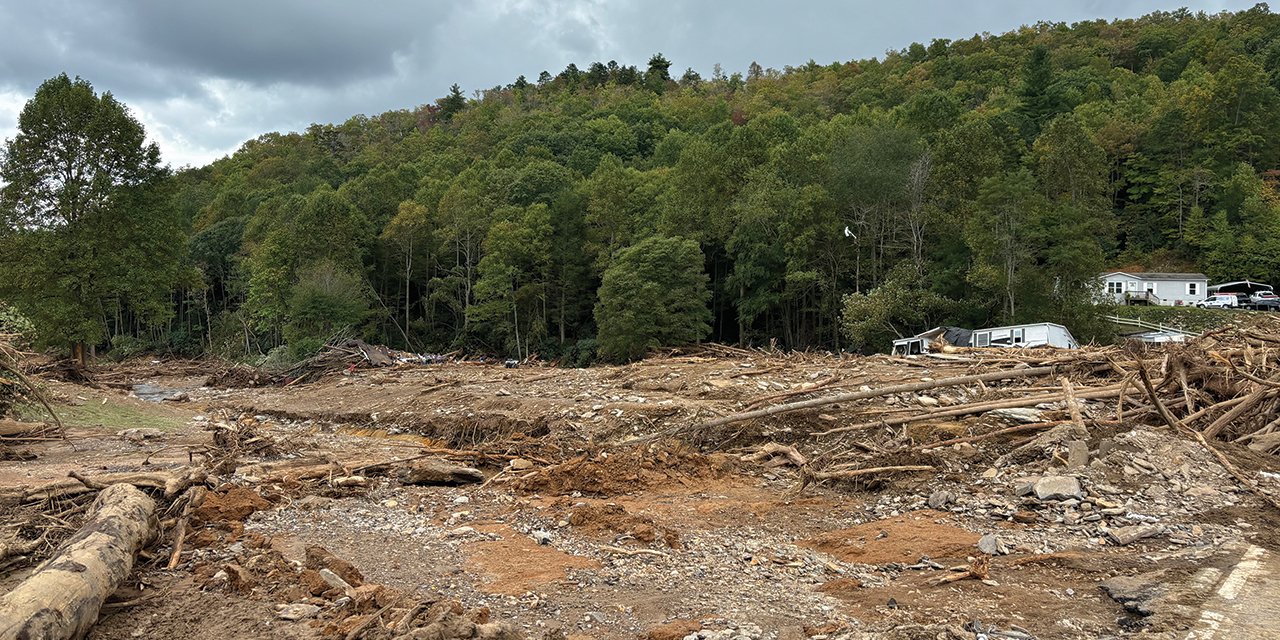 there is a lot of debris in the middle of a field with a house in the background .