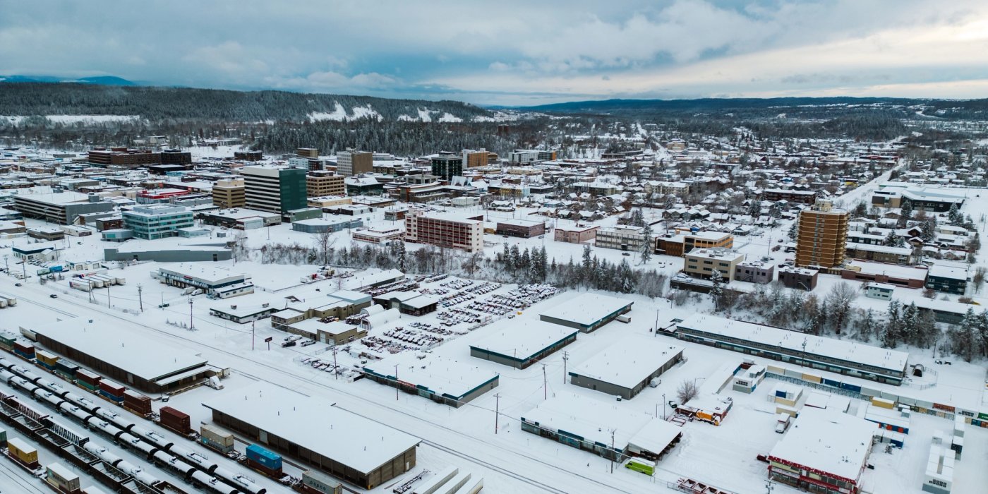 an aerial view of the city of Prince George covered in snow .