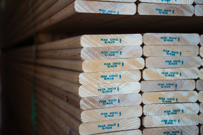 a stack of wooden decking boards stacked on top of each other in a warehouse .