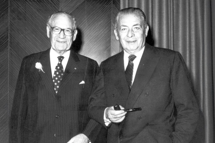 two men in suits and ties are standing next to each other