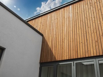 Modern building facade with white and wood paneling.