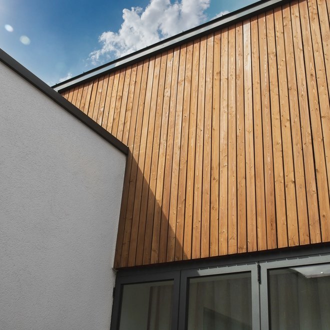 Modern building facade with white and wood paneling.