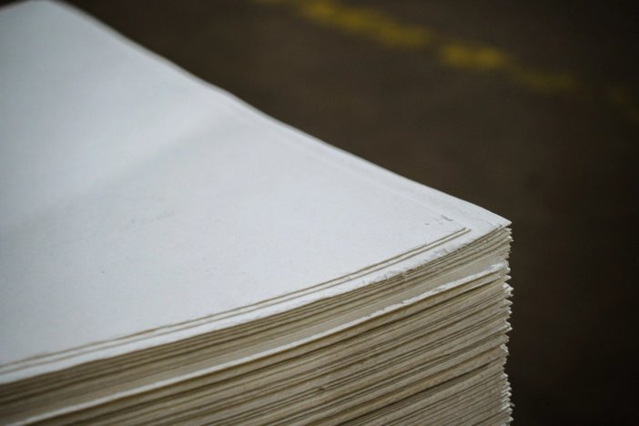 a close up of a stack of white paper on a table .