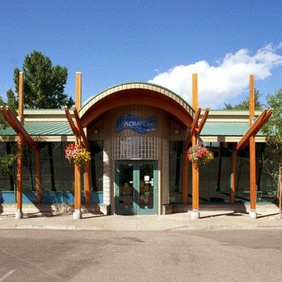 the front of a building with a green roof and wooden beams.