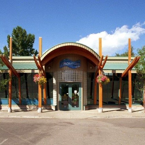the front of a building with a green roof and wooden beams.