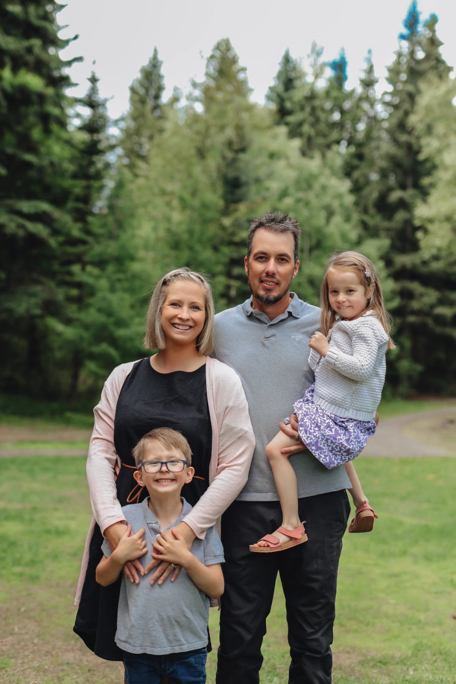 a family posing for a picture with trees in the background