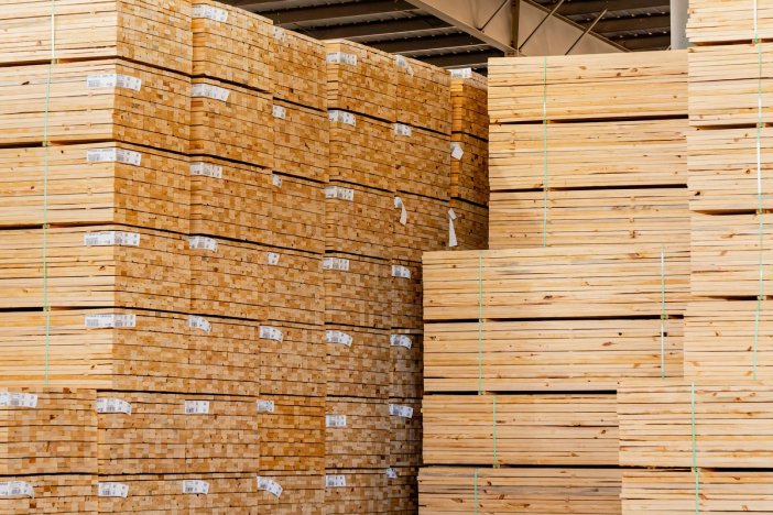 a warehouse filled with lots of wooden boards stacked on top of each other .