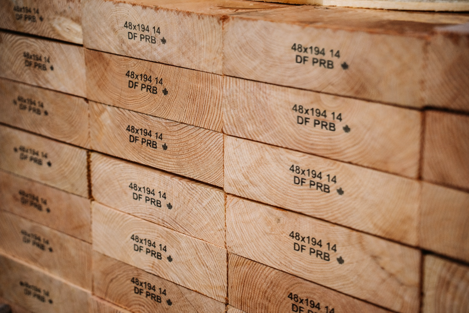 Stack of wood planks with "48x194 14 DF PRB" stamped on their ends.