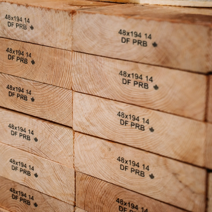 Stack of wood planks with "48x194 14 DF PRB" stamped on their ends.