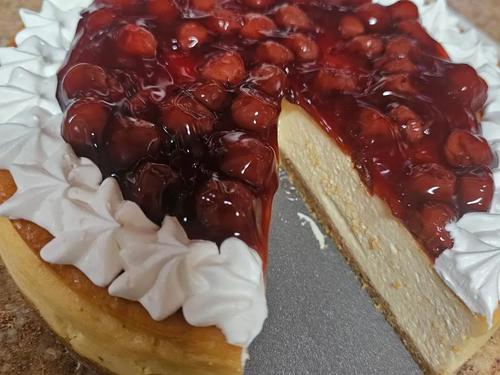 Classic cheesecake with cherry topping and whipped cream