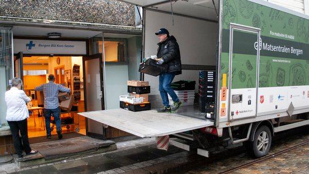 Mann som tømmer en varebil med mat fra Matsentralen