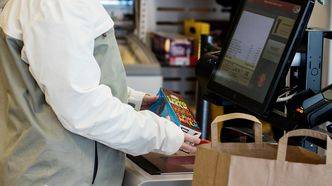 En kunde skanner et produkt i en selvbetjent kasse