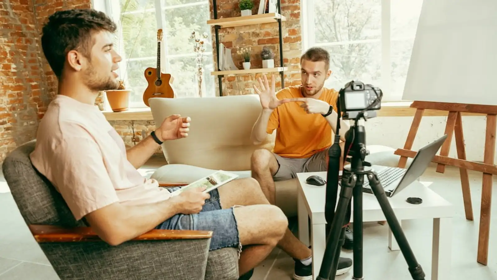 due uomini seduti sul divano intervista con telecamera.jpg