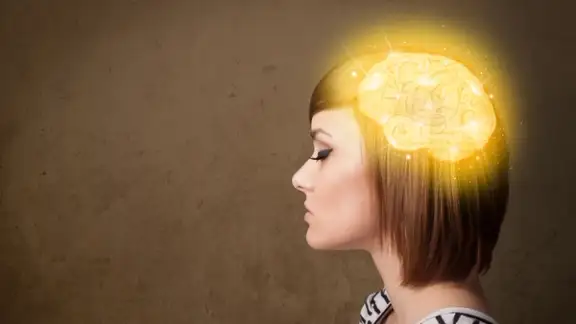 Young girl thinking with glowing brain illustration on grungy background.jpeg