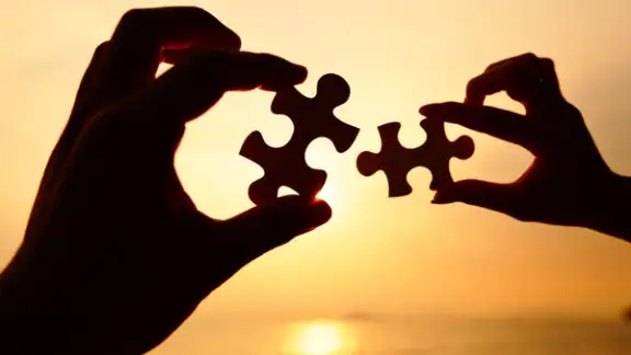 Man and woman hands trying to connect puzzle pieces.jpeg