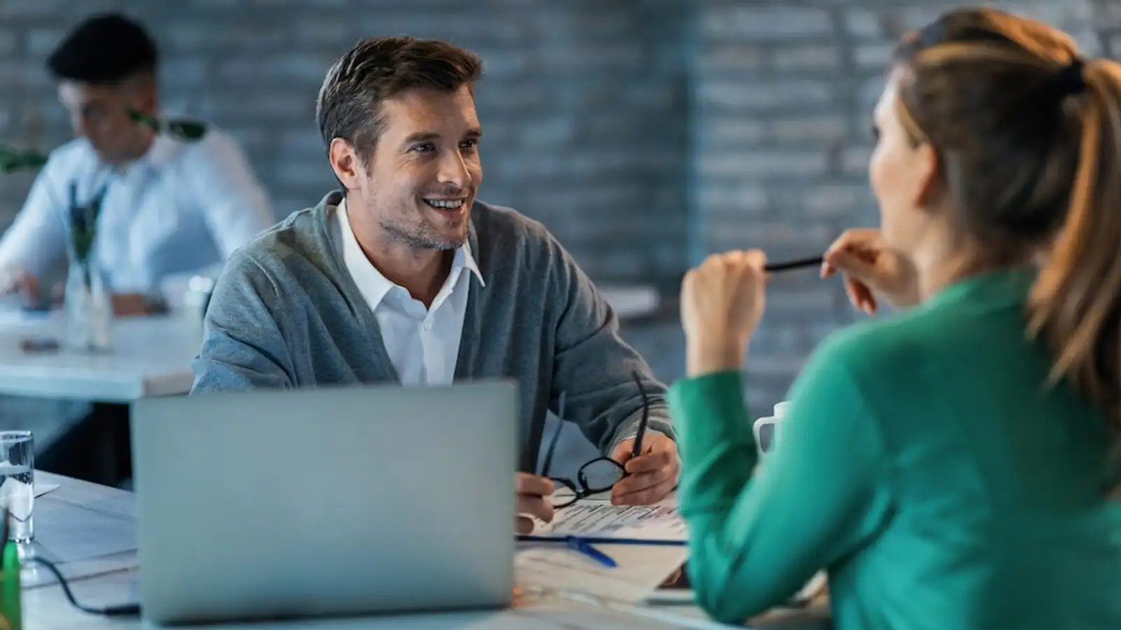 due persone parlano sedute in una scrivania.jpg