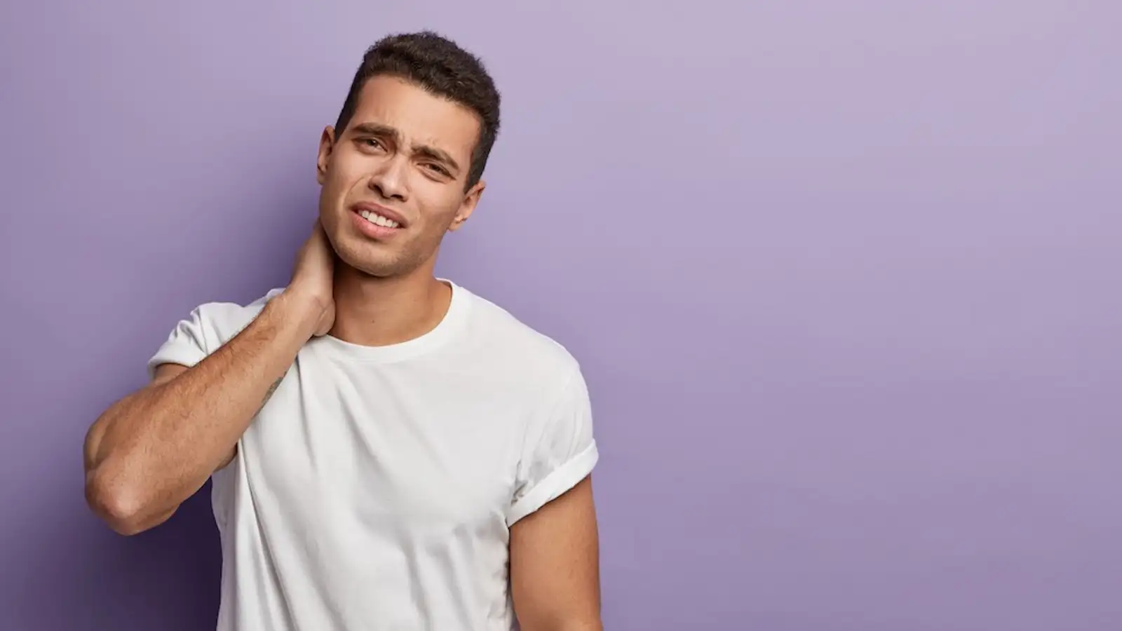 ragazzo si massaggia il collo dove ha dolore.jpg