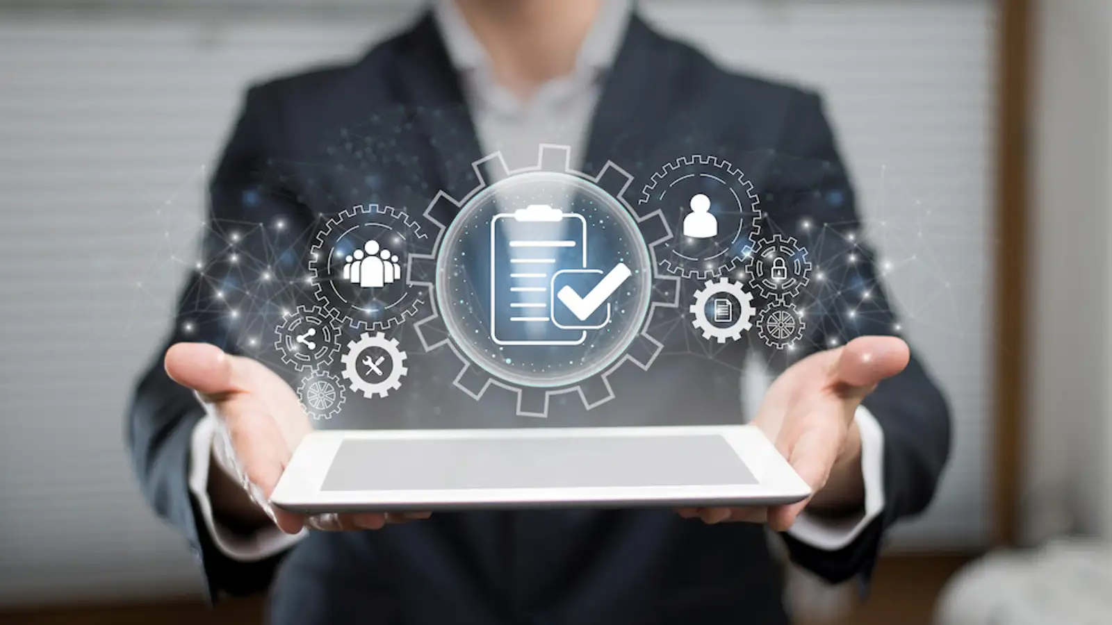 persona con tablet in mano con ologrammi di ingranaggi.jpg