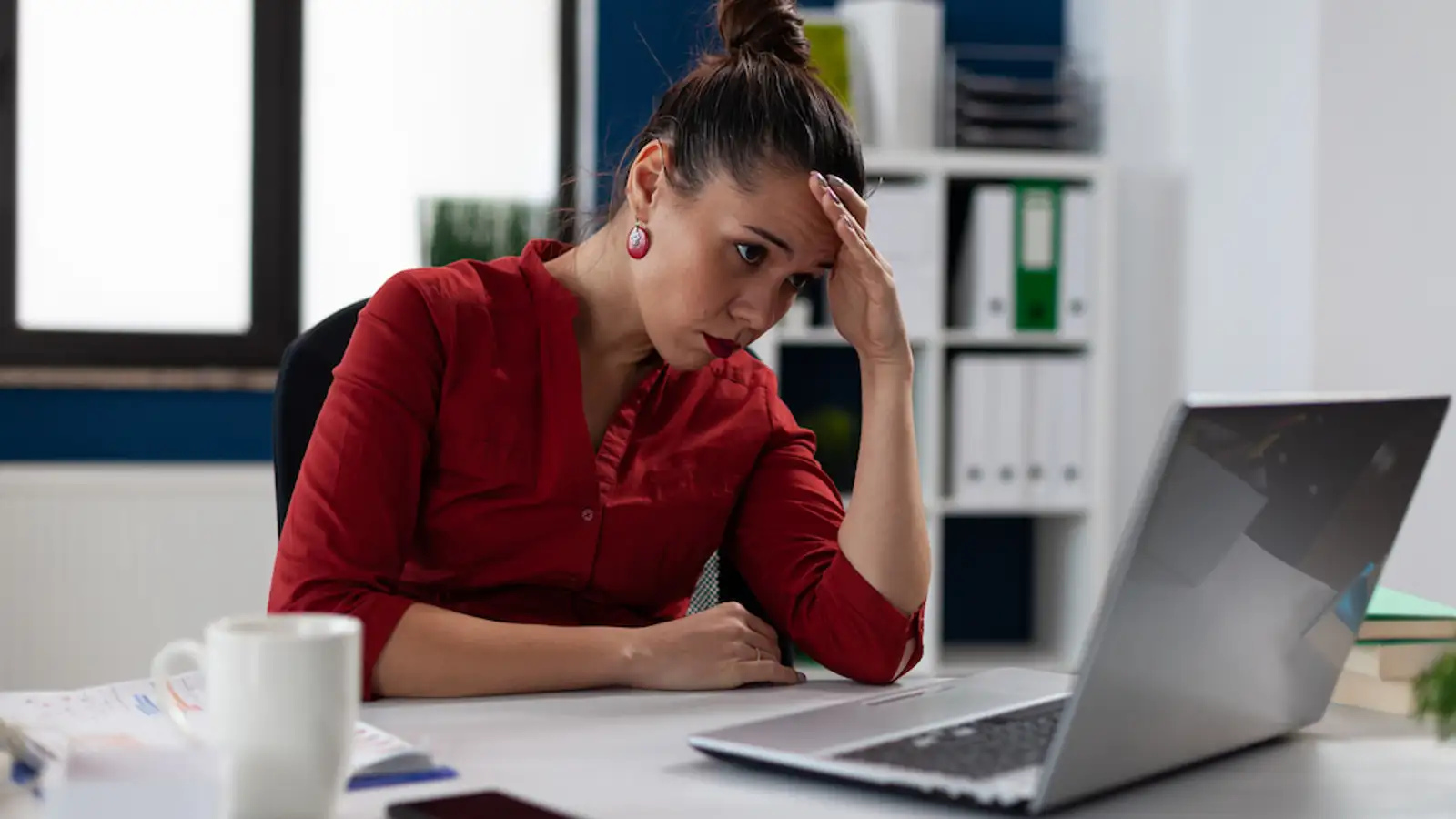 donna stanca seduta davanti al pc con mano sulla testa.jpg