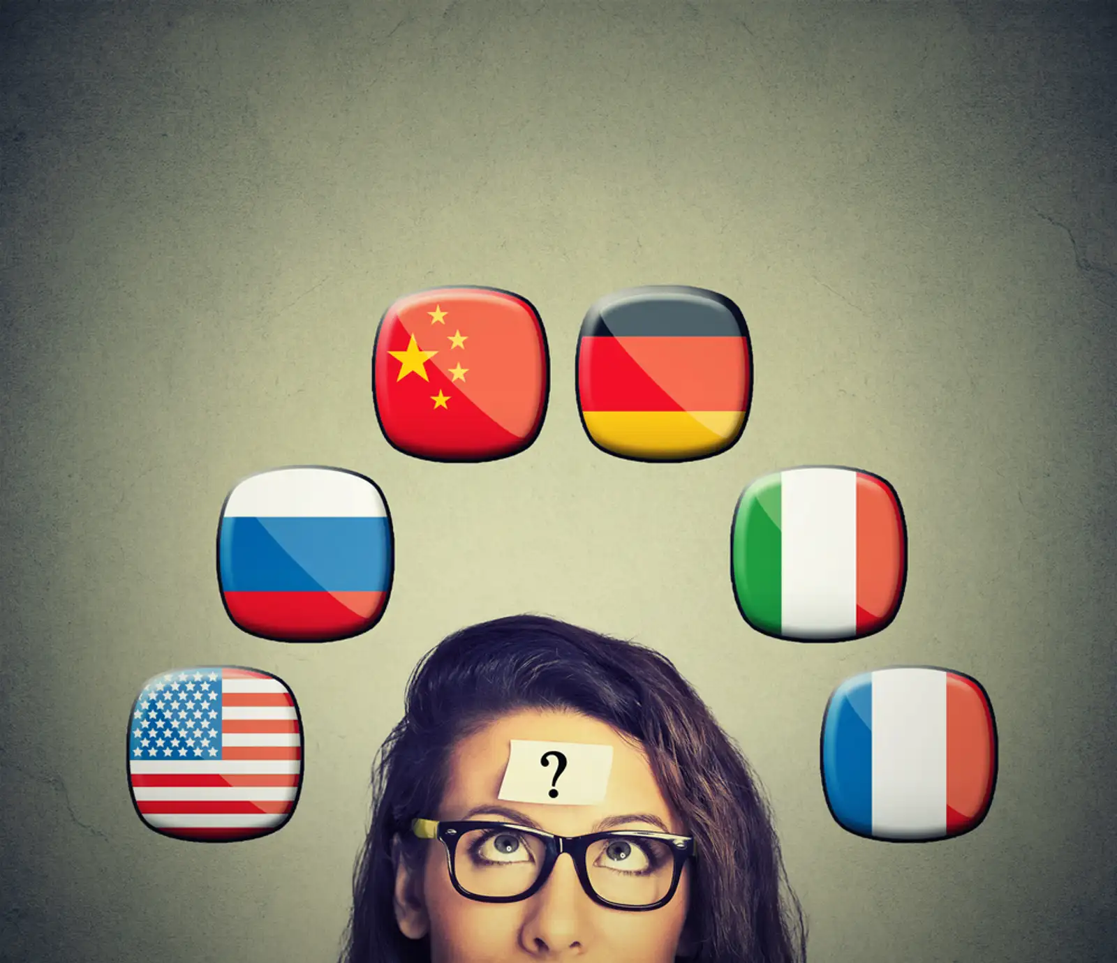 Work and travel immigration opportunity concept. Foreign language studying process. Woman with question mark and icons of international flags above head isolated on gray wall background..jpeg