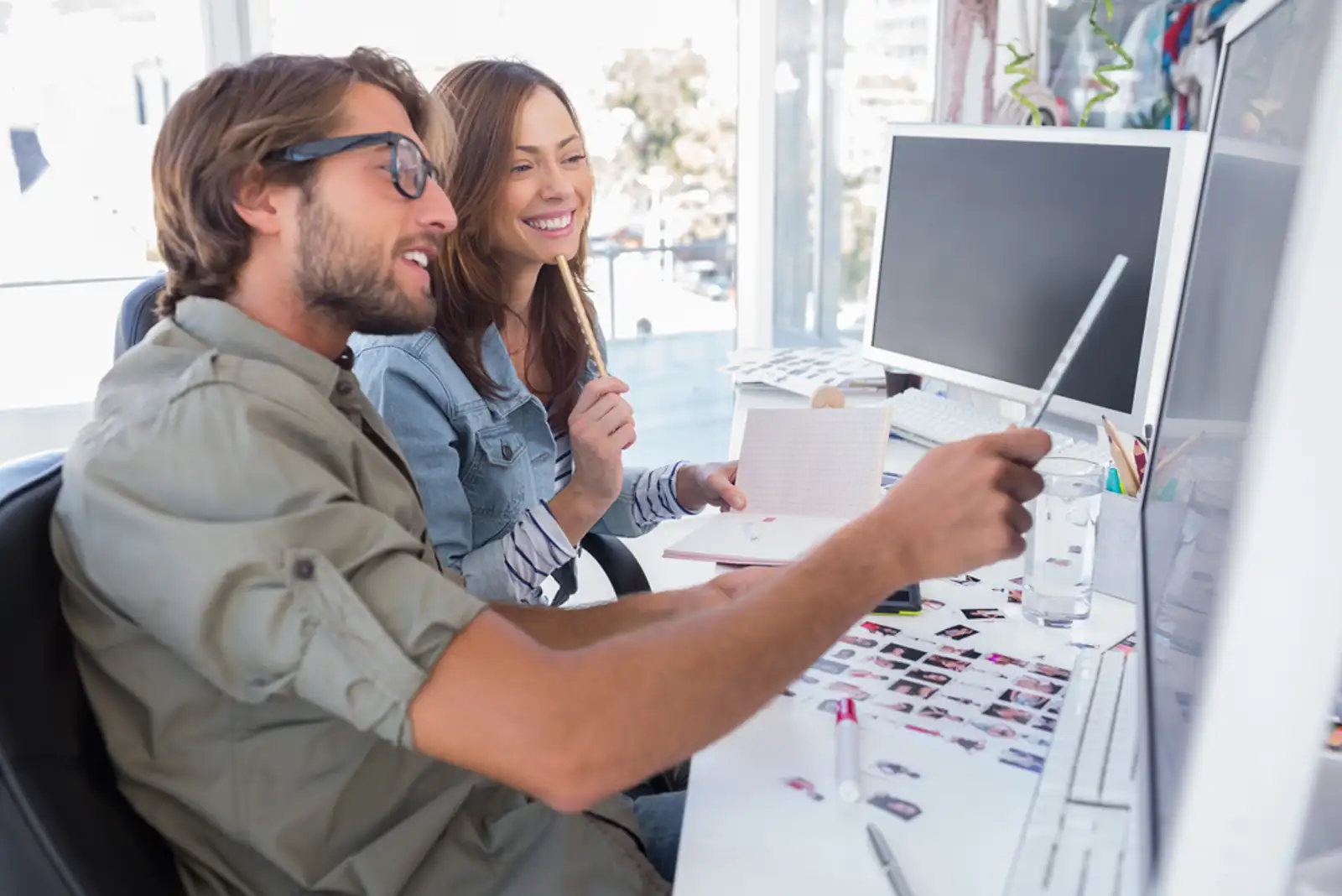 Photo editors working together at desk and smiling in bright modern office.jpeg