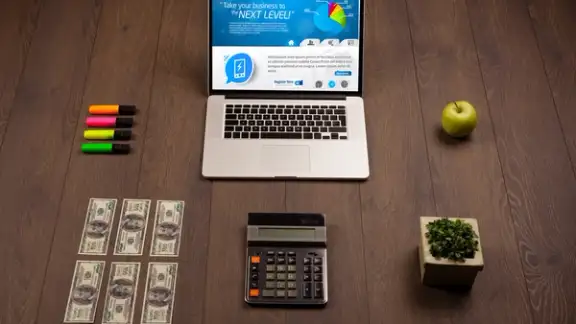 Laptop on office wooden desk with business website on screen.jpeg