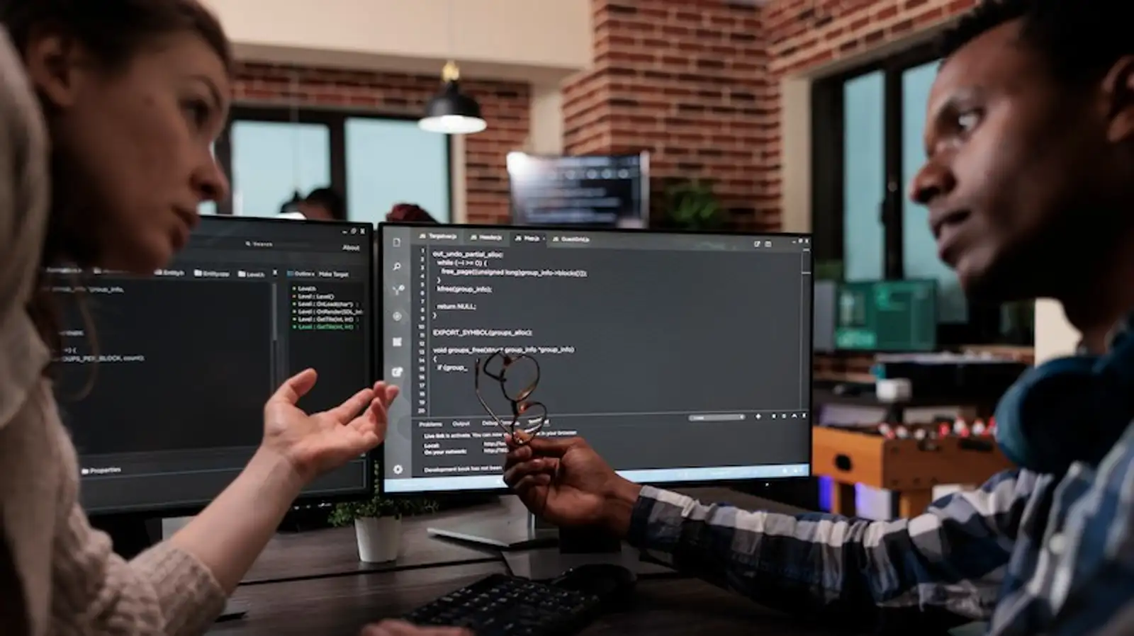 informatici al computer indicano schermo e parlano.jpg