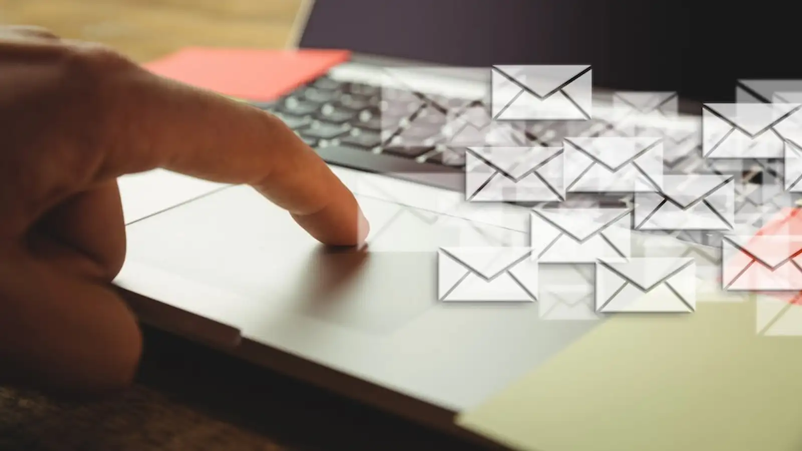 mano tocca un compurter portatile con simboli di email.jpg